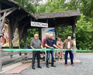 Frontenac County Warden Dennis Doyle cuts the ribbon, held by South Frontenac Counillor Ray Leonard and Mayor Ron Vanderwal.